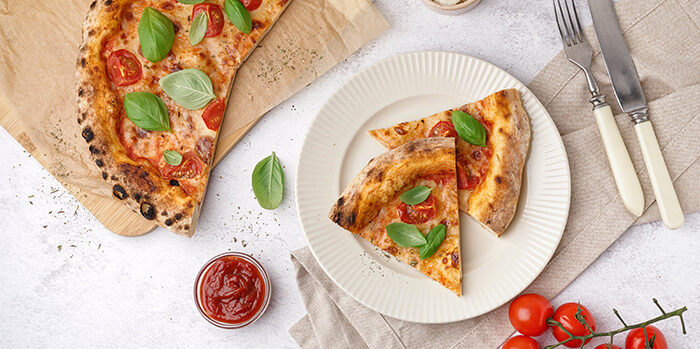 parts de pizza au légumes sur une assiette en carton
