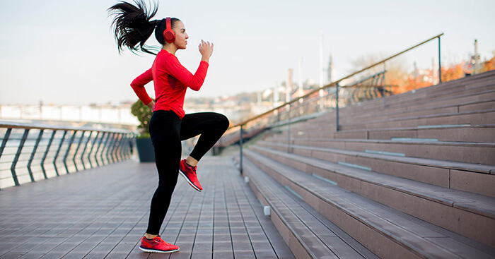 femme en tenue de sport pratiquant une activité cardio en extérieur