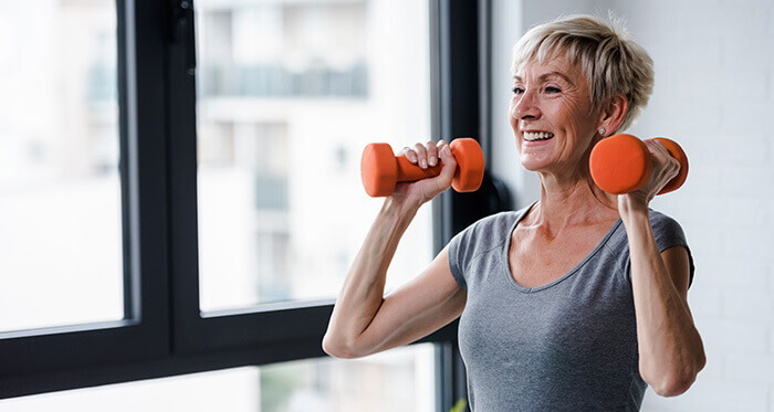 femme senior pratiquant la musculation avec des haltères