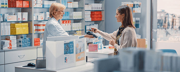 femme payant un achat au comptoir d'une pharmacie
