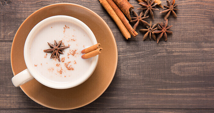 tasse de masala chai entourée d'épices