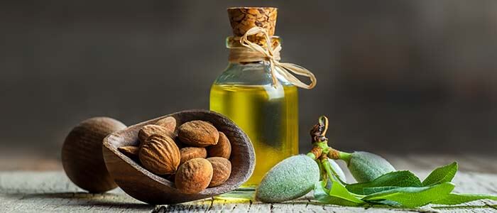 flacon d'huile d'amande douce avec des amandes