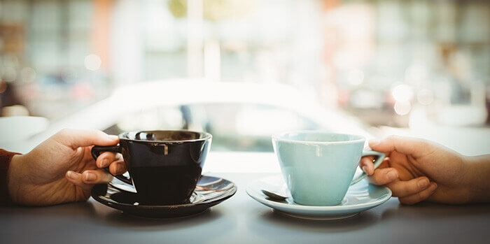 plan sur deux tasses de café posées sur un comptoir face à une vitrine