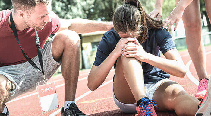 athlète venant de se blesser le genou sur le terrain