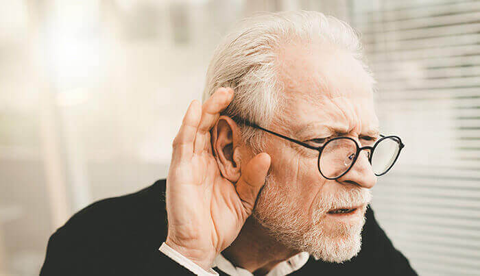 homme âgé tendant l'oreille suite à un trouble de l'audition