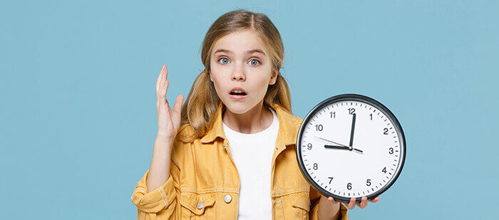 filette à l'air tourmenté tenant une horloge