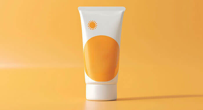 tube de crème solaire sur fond orange