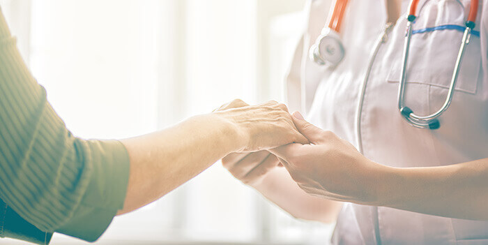 médecin tenant les mains d'un patient en soutien