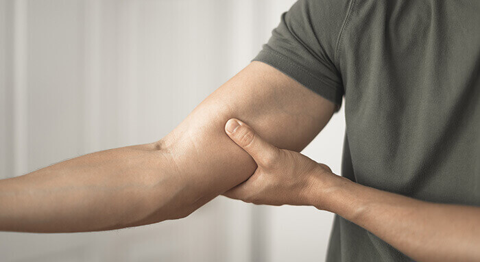 focus sur le bras d'un homme souffrant de douleurs musculairess