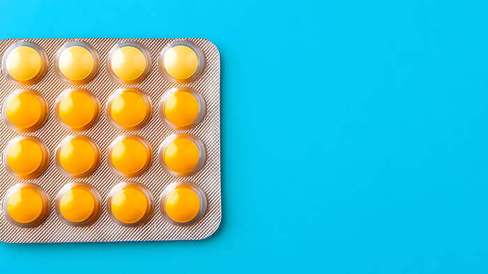 Plaquette de pastilles pour la gorge sur fond bleu