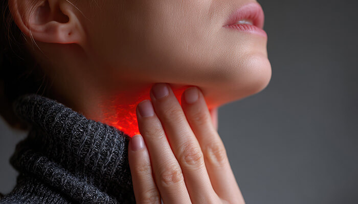 plan sur la gorge inflammée d'une femme en col roulé