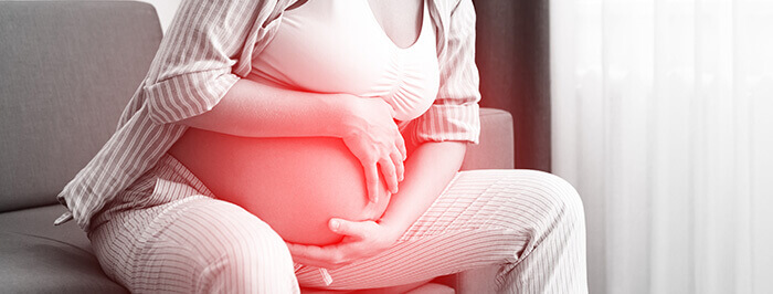 Plan sur un ventre de grossesse pendant une contraction