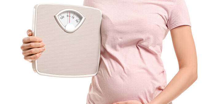 femme enceinte tenant une balance