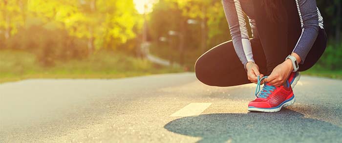 personne enfilant une paire de baskets pour aller faire du sport