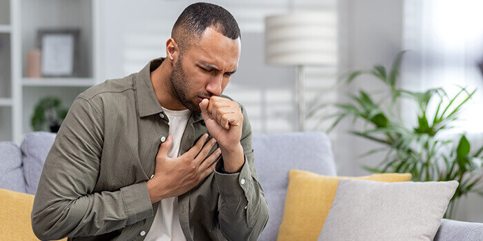 homme allergique, toussant et se tenant la poitrine