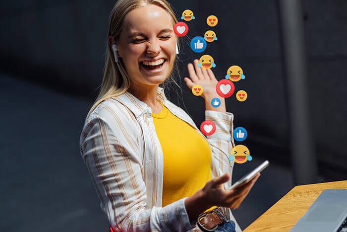 femme très souriante face à l'afflux de notifications sur son smartphone