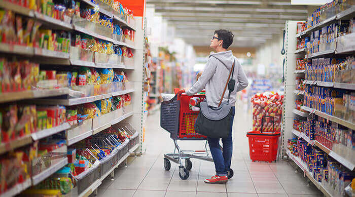 femme dans un rayon de supermarché en train de faire ses courses