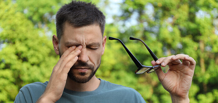 homme souffrant d'une conjonctivite et se frottant l'œil