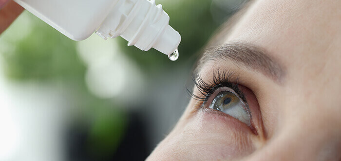 femme s'appliquant des gouttes ophtalmiques dans l'œil