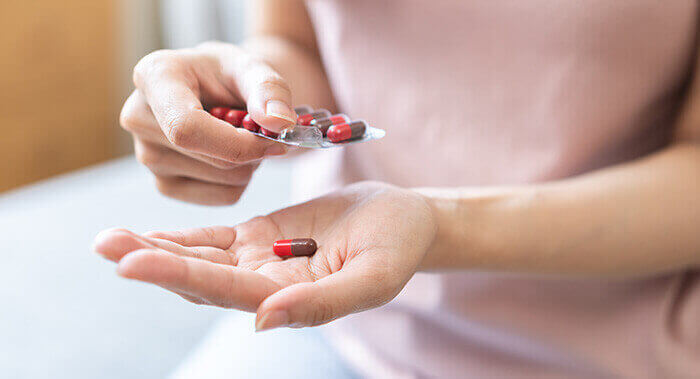 femme prenant une gélule d'aspirine