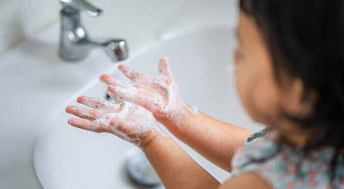 Filette en train de se laver les mains avec du savon et de l'eau