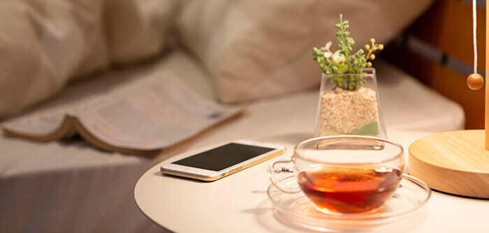 tasse de tisane posée sur une table de nuit