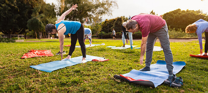 groupe de personnes pratiquant de la gym dans un parc