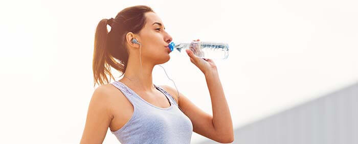 femme qui boit une bouteille d'eau