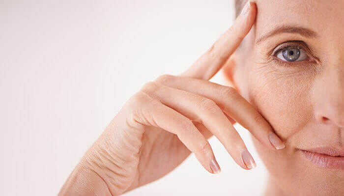 gros plan sur les ridules autour des yeux d'une femme à la peau mature