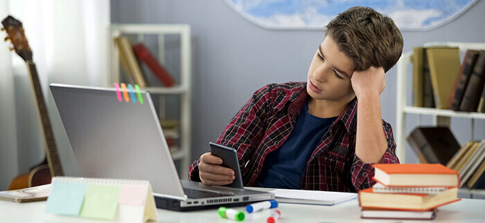 garçon adolescent procrastinant sur son smartphone