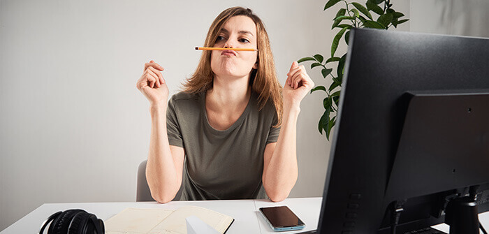 femme procrastinant au bureau en jouant avec un crayon