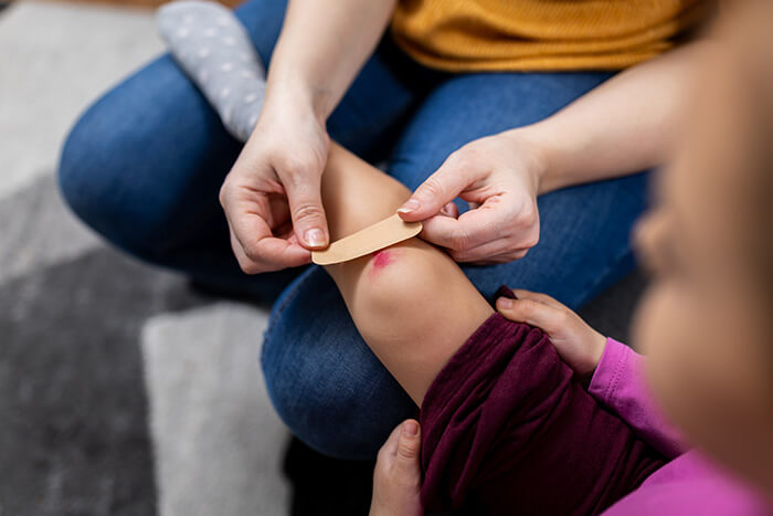 Pansement appliqué sur le genou egratigné d'un enfant