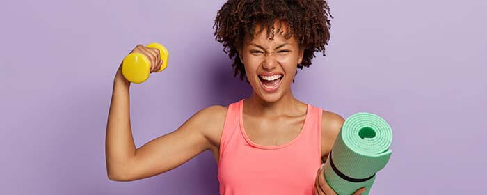femme portant une haltère et un tapis de gym