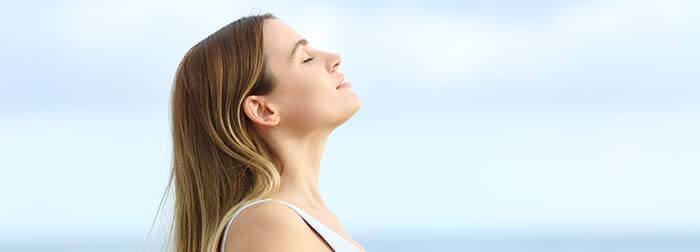 femme de profil inspirant profondément