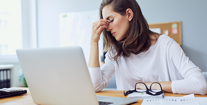 femme à son bureau, présentant des signes de fatigue