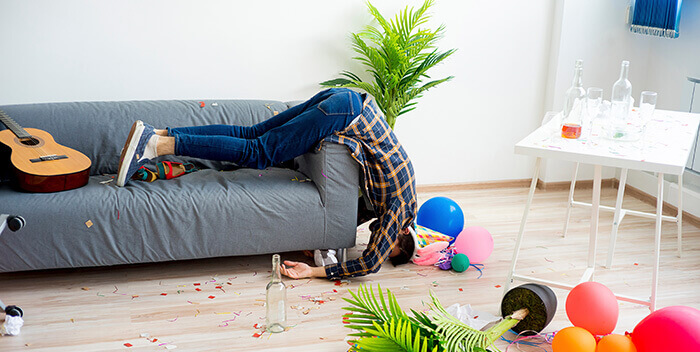 homme dans une position incongrue sur un canapé le lendemain d'une soirée arrosée