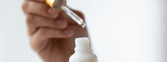 pipette avec goutte de sérum au dessus d'un flacon