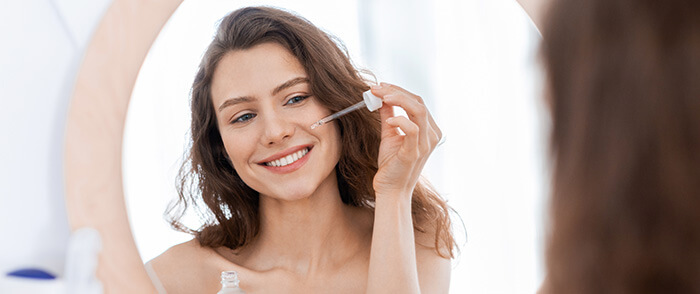 jeune femme s'appliquant du sérum