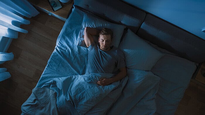 homme dormant paisiblement dans son lit