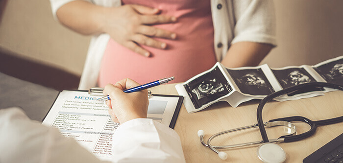 femme enceinte chez le gynécologue dans le cadre d'un suivi de grossesse