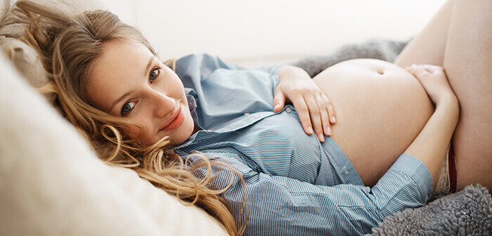 femme enceinte souriante en culotte