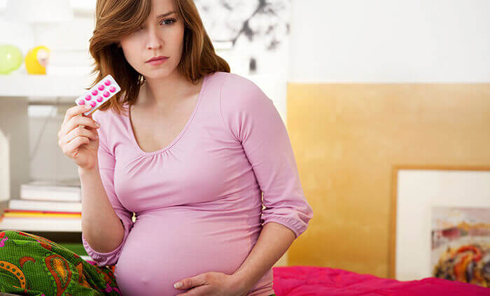 femme enceinte prenant un comprimé de spasfon