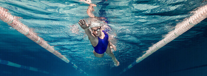 femme en train de nager dans une piscine