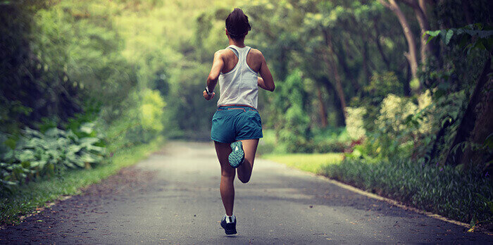femme de dos en train de faire un jogging