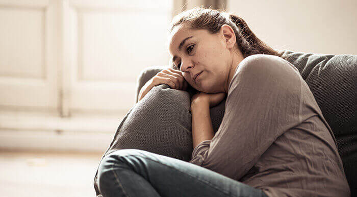 femme déprimée se lovant dans son canapé