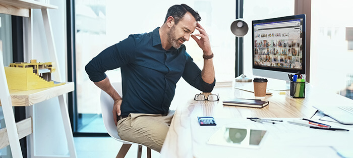 homme souffrant de la tête et du dos au bureau