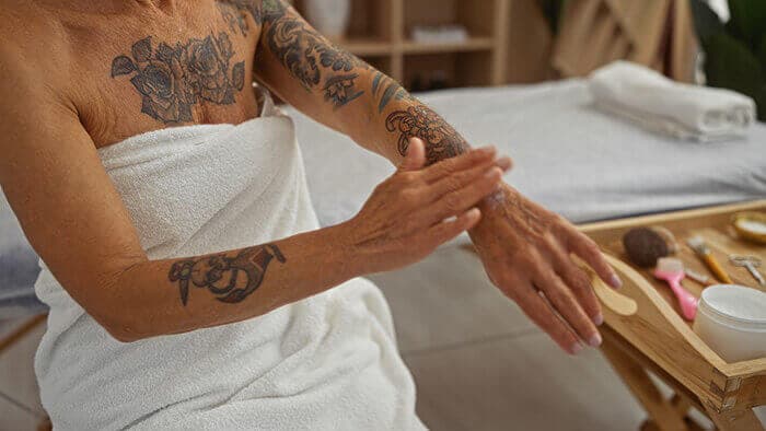 femme nettoyant un tatouage sur son bras