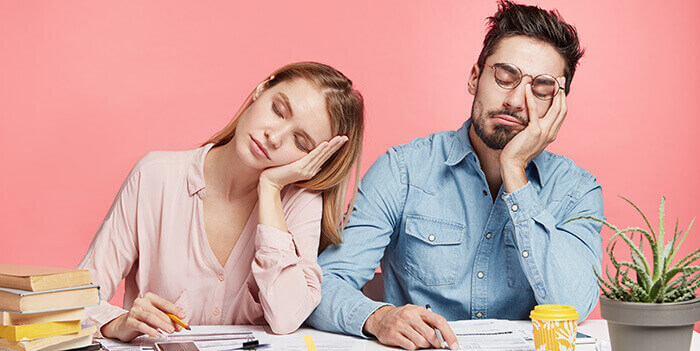 couple somnolant assis à un bureau