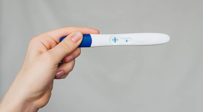 test de grossesse positif tenu par une main de femme