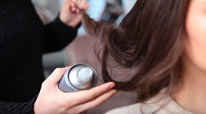 application de laque sur des cheveux